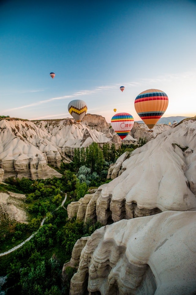 Hot air balloons rising over Cappadocia at sunrise